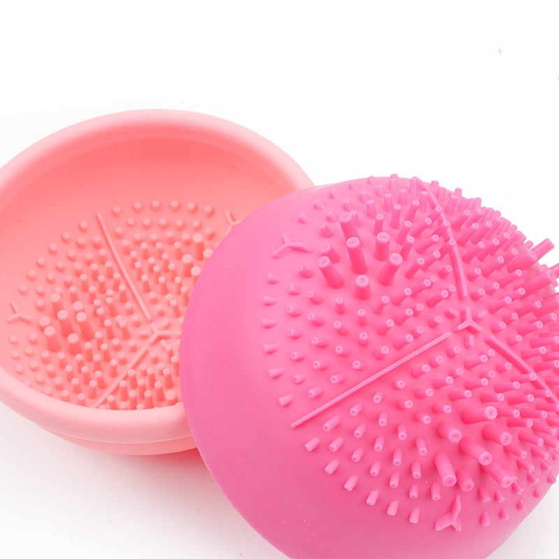 Pink and coral silicone makeup brush cleaner with textured bristles, center mold design
