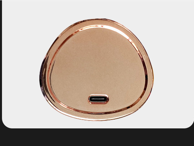 Copper-colored round cordless hair curler base with USB port centered
